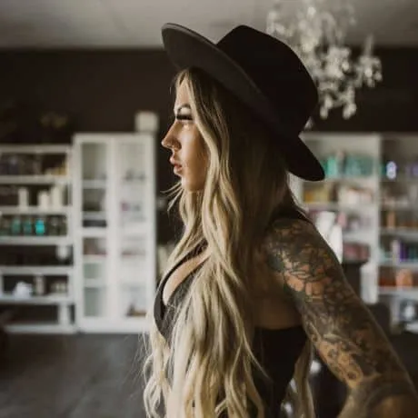 Woman in hat side profile in Bombshell Boutique Hair Salon
